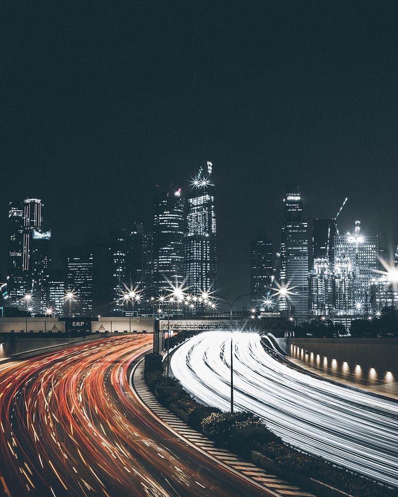 Streaks of light from cars with the city skyline as the backdrop